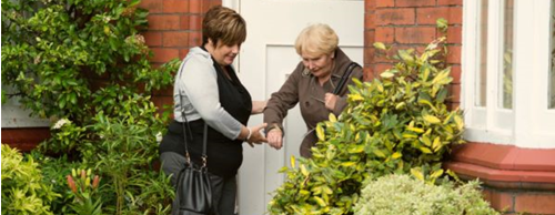 CareGiver assisting a lady to step out of her house