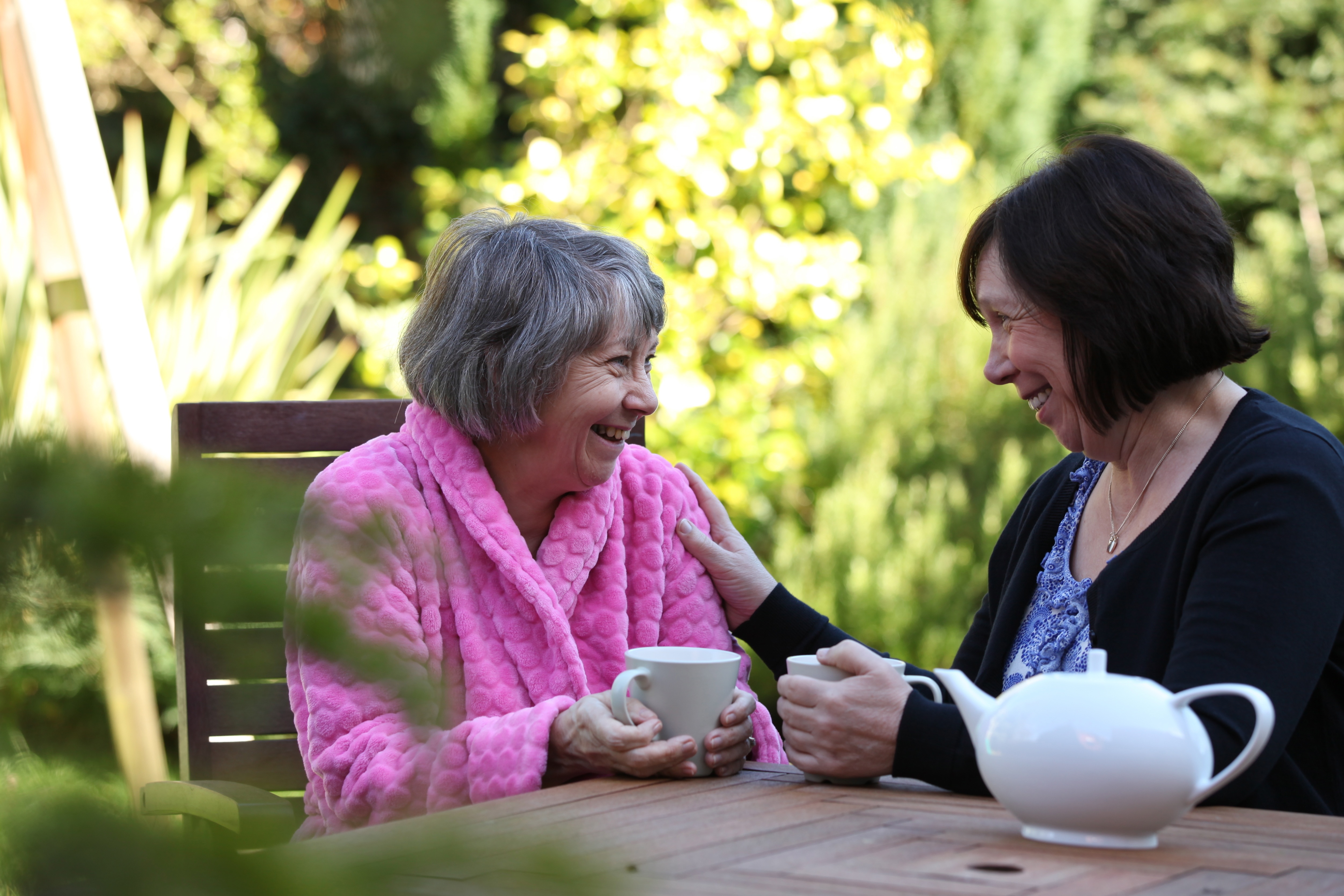 Client And Caregiver Sat Outside Drinking Tea