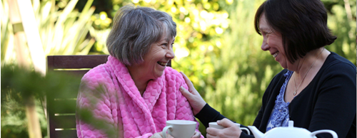 CareGiver and Client laughing and drinking tea outside