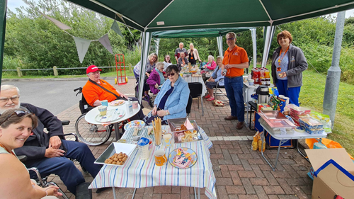 Right at Home North Somerset carers and Clients eat picnic under green gazebo