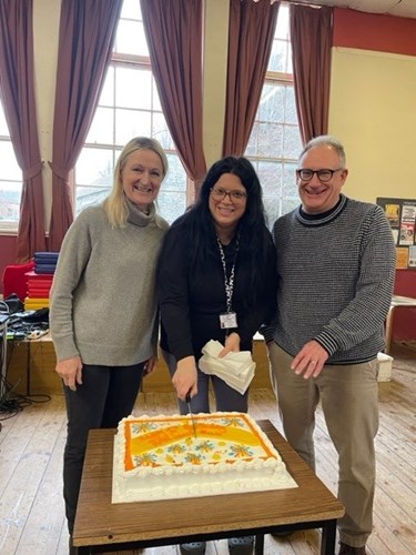 Director and Community Coordinator cutting celebration cake