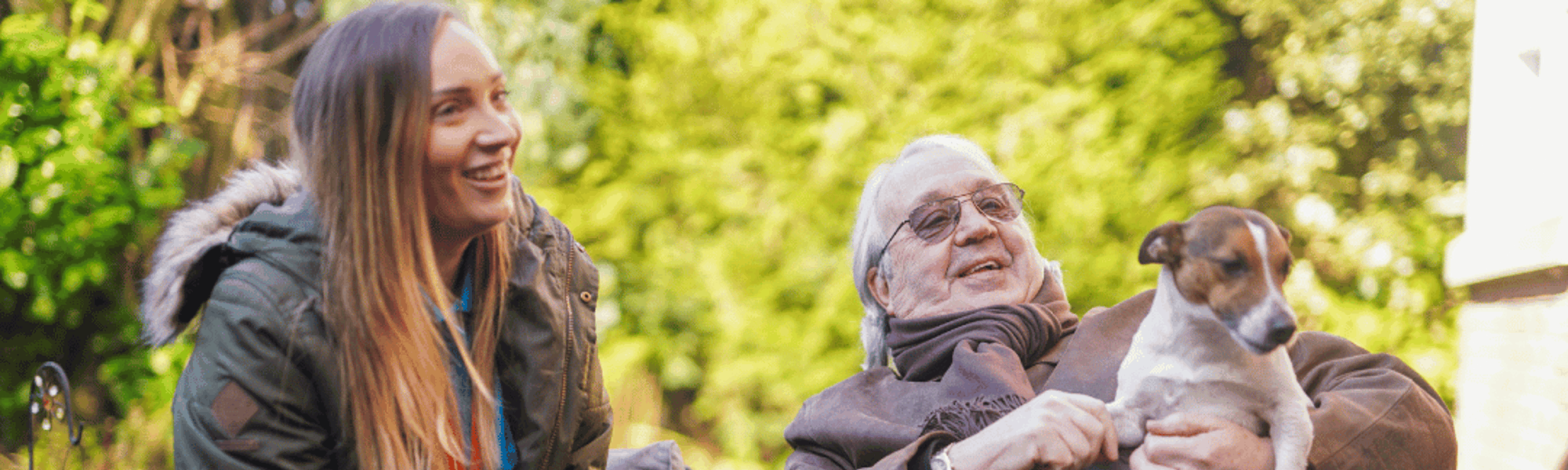 Woman and elderly gentleman sitting on a bench talking