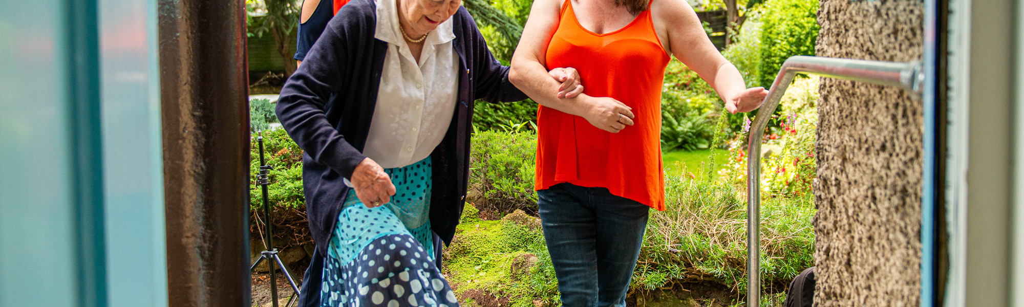 CareGivers helping client through doorway