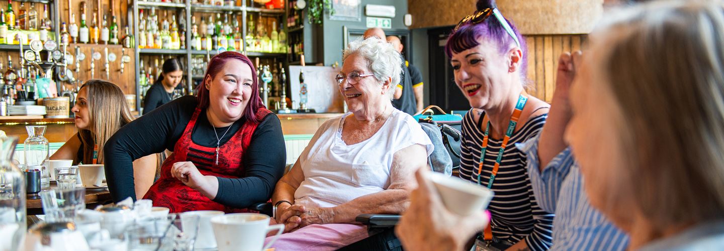 Elderly clients and care givers in a cafe